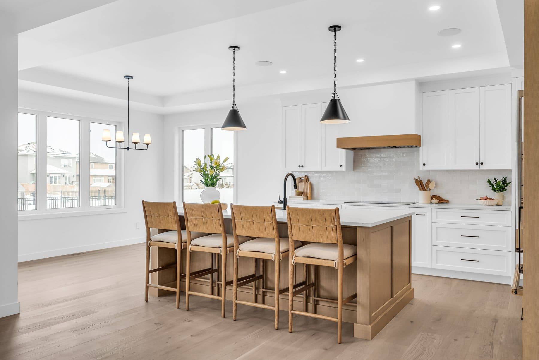 Bright kitchen with a wood island and black pendant lights